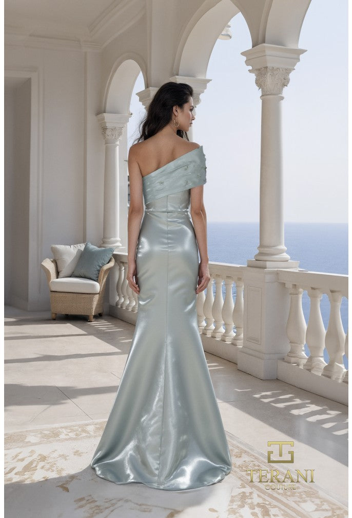 Woman in a sage color evening gown on a balcony with ocean view, Terani brand visible