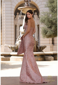 Woman in a pink evening gown standing in front of a fountain