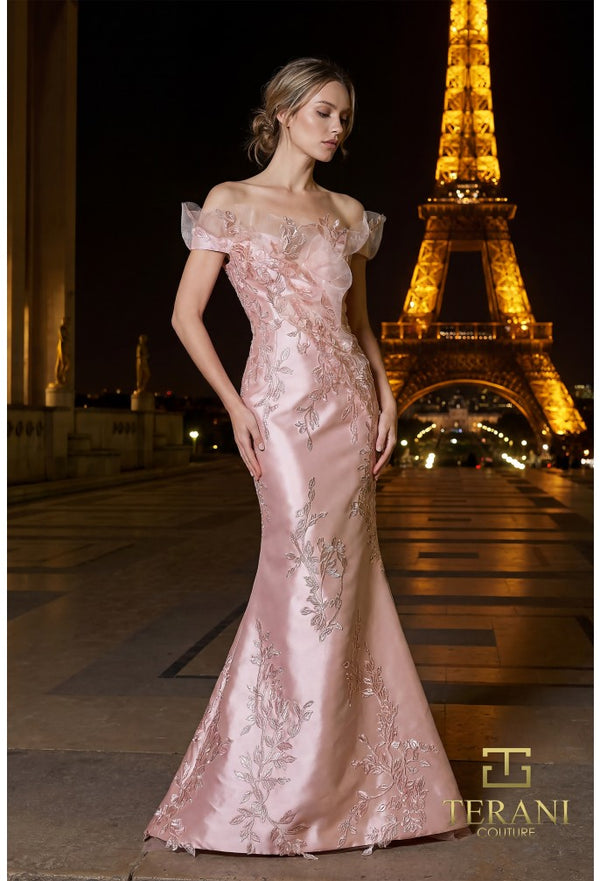 Model wearing the Terani Couture 261E6270 off-the-shoulder fitted gown with floral embellishments and a sweep train.