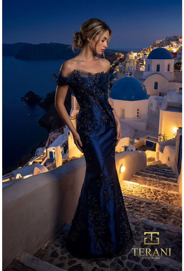 Model wearing the Terani Couture 261E6270 off-the-shoulder fitted gown with floral embellishments and a sweep train.