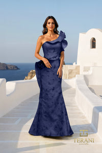 Woman in a Navy evening gown standing on a white staircase with ocean view, Terani brand visible