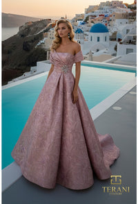 Woman in a pink gown standing by a pool with a scenic background, featuring Terani Couture logo.