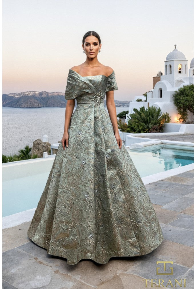 Woman in a green evening gown standing by a pool with a scenic background