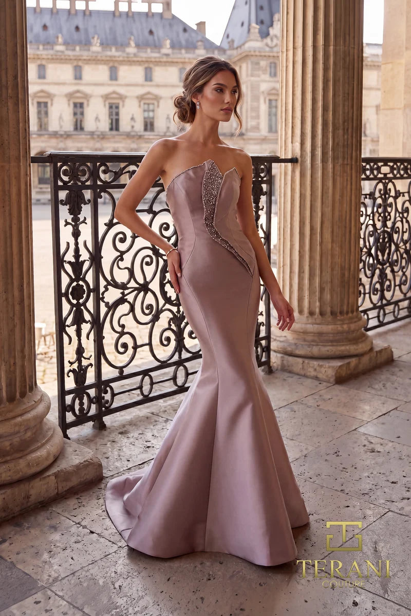 Woman in a mink color Terani Couture evening gown standing on a balcony with classical architecture in the background.