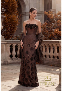 Woman in a bronze color strapless gown with floral details standing outdoors.