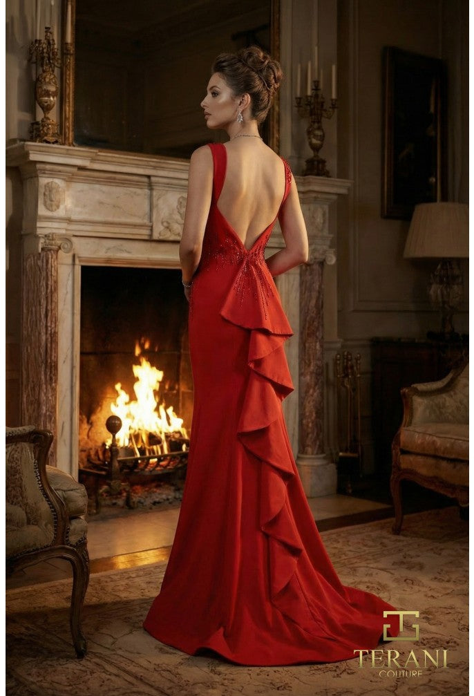 Woman in a red evening gown standing in a room with a fireplace, wearing a Terani dress.