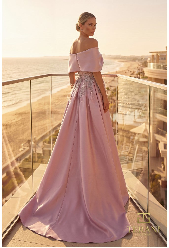 Model wearing Terani Couture 262M7271 off-the-shoulder gown with embroidered appliqués, detachable overskirt, and floor-length silhouette.