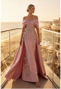 Model wearing Terani Couture 262M7271 off-the-shoulder gown with embroidered appliqués, detachable overskirt, and floor-length silhouette.