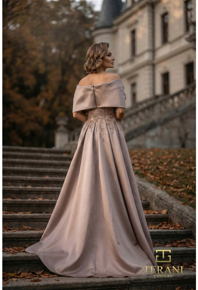 Woman in a elegant off-shoulder dress standing on steps in front of a castle.