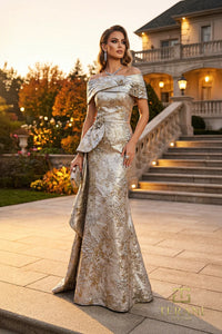 Woman in a glamorous off-shoulder evening gown standing in front of a mansion.