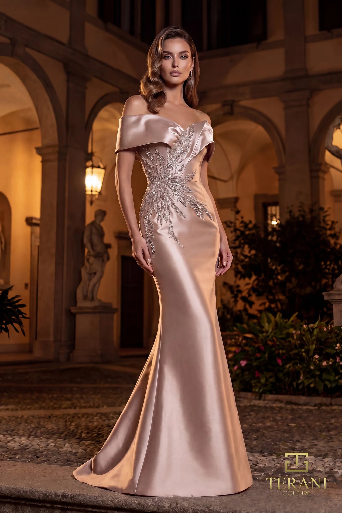 Woman in a elegant evening gown standing in an outdoor setting with classical architecture.