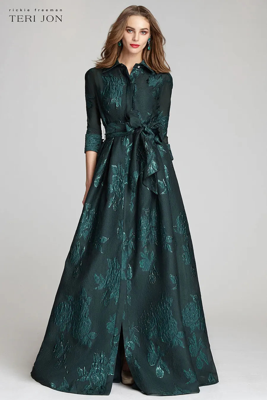 Model wearing Teri Jon 207015 floral shirt gown with a collared neckline, sash belt, three-quarter sleeves, and full A-line skirt.