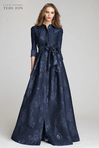 Model wearing Teri Jon 207015 floral shirt gown with a collared neckline, sash belt, three-quarter sleeves, and full A-line skirt.