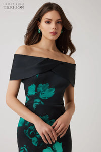Model wearing Teri Jon 257008 off-the-shoulder column gown with bold floral print, ideal for formal evenings and mother of the bride or groom occasions.