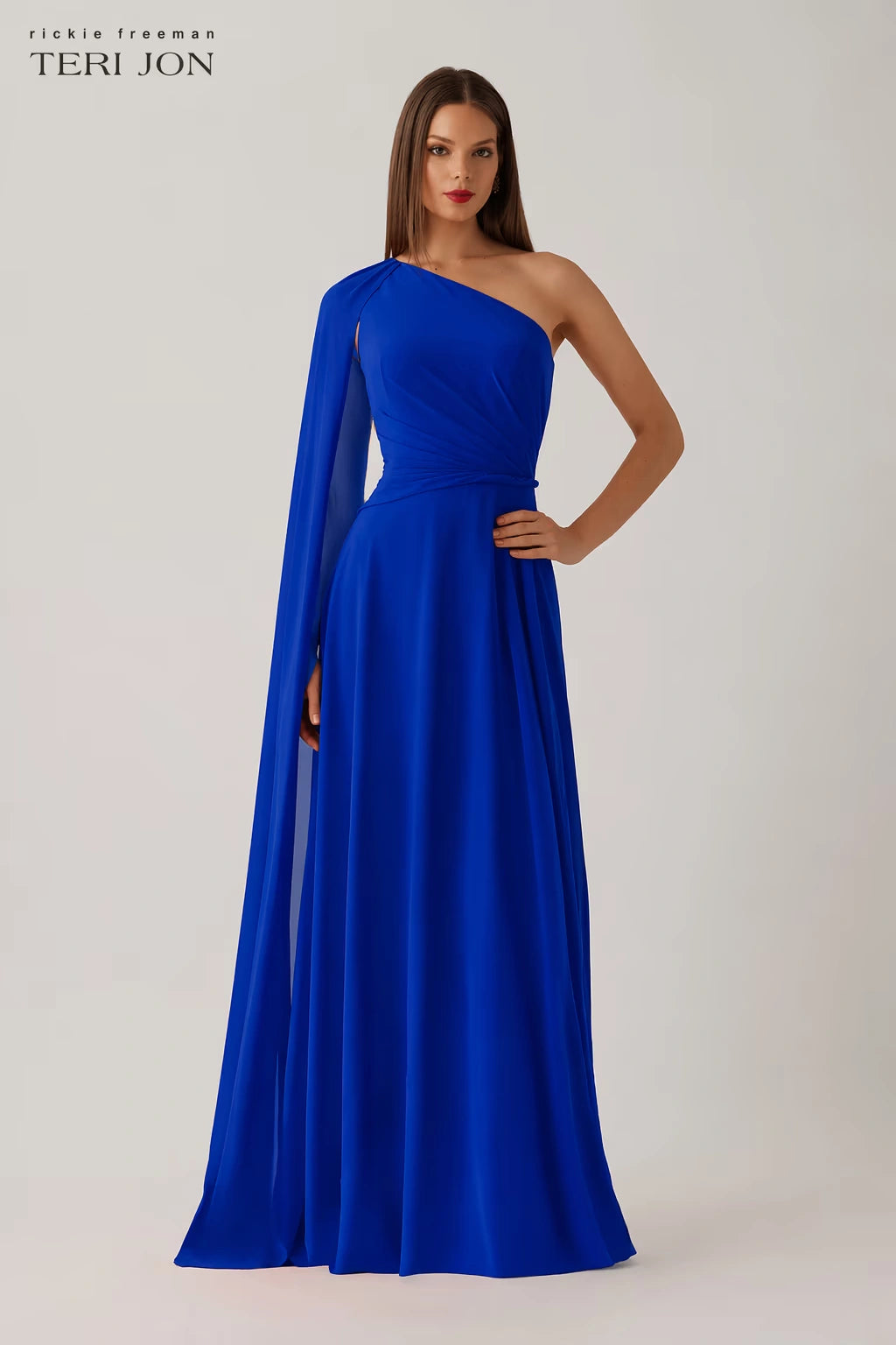 Model wearing Teri Jon 266020 one-shoulder evening gown with cape sleeve detail.