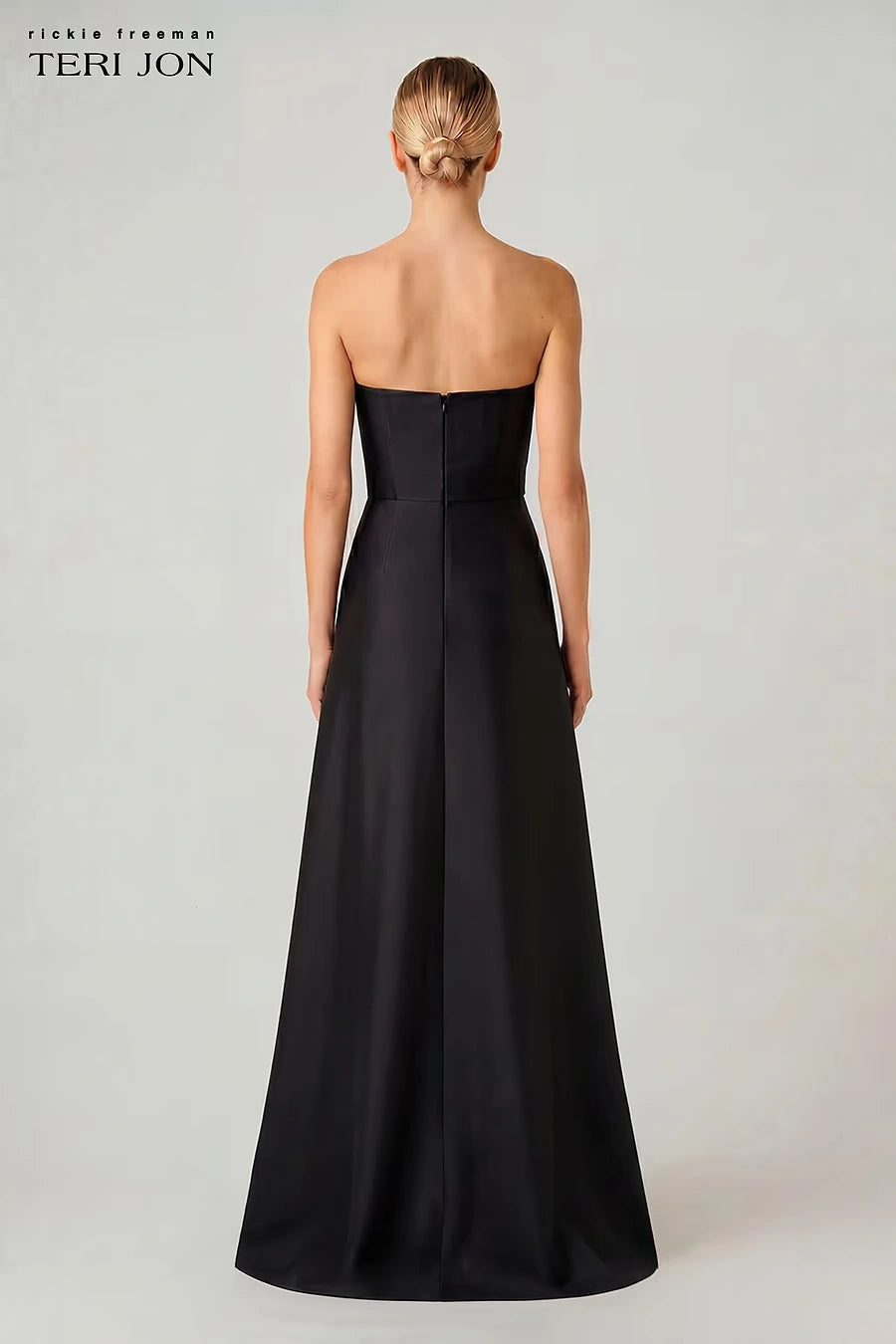 A woman shown from the back wearing a strapless black floor-length gown against a light gray studio background. The brand text 'richie freeman TERI JON' appears in the upper left corner.