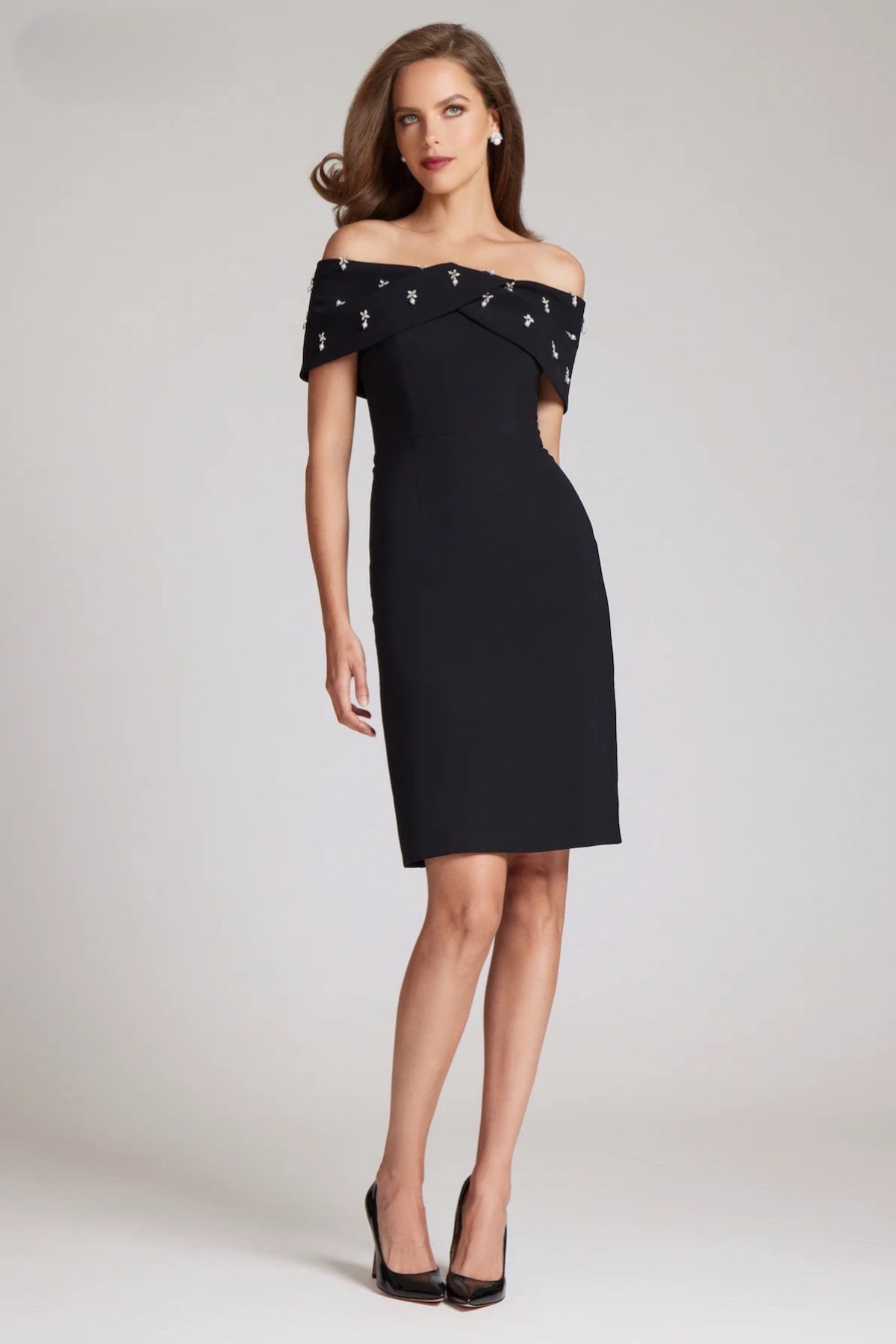 Elevate your style with Teri Jon style 237280 little black dress. Straight fit silhouette with off-the-shoulder sleeves and jeweled detailing. Perfect for cocktail parties and special events. Available at Madeline's Boutique, Toronto & Boca Raton.