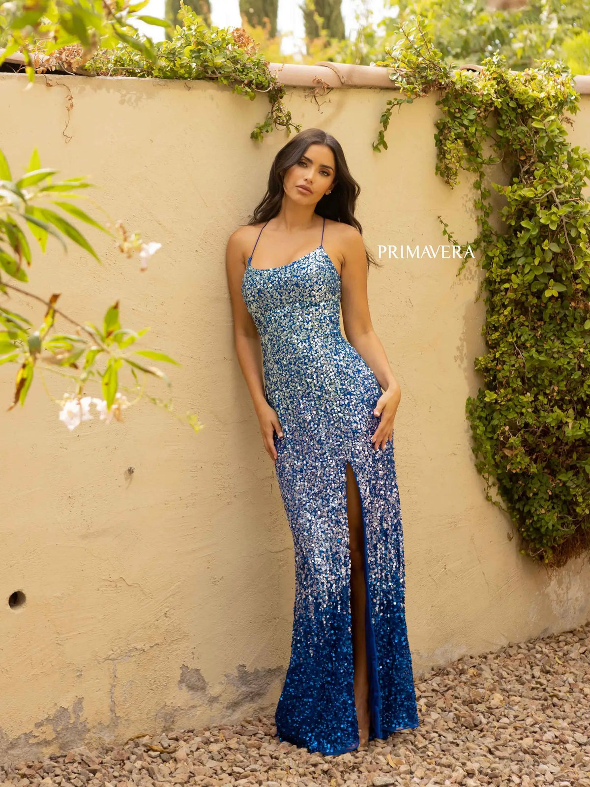 Get ready to shine at prom with this stunning blue sequin dress by Primavera, available at Madeline's Boutique in Toronto and Boca Raton. The fitted silhouette, low back, and strappy criss-cross detail add modern elegance and sexiness to this luxurious sequined gown