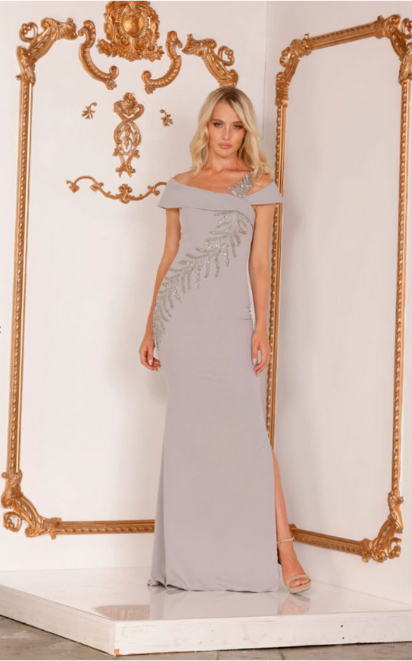 Make a statement in this stunning Terani Couture off-shoulder mother of the bride dress. The trumpet cut, asymmetrical crystal embellishments, and side slit create a glamorous silhouette. Perfect for any formal occasion. Sold by Madeline's Boutique in Toronto, Canada and Boca Raton, Florida